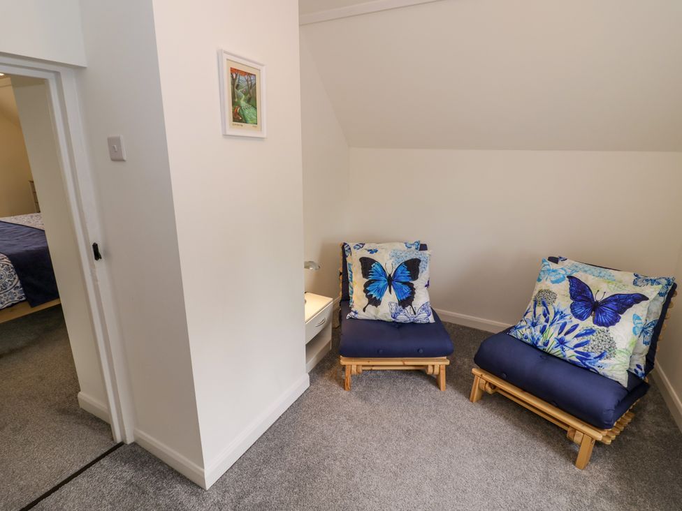 A bedroom with two chairs and a painting at The Cottage in Ettington