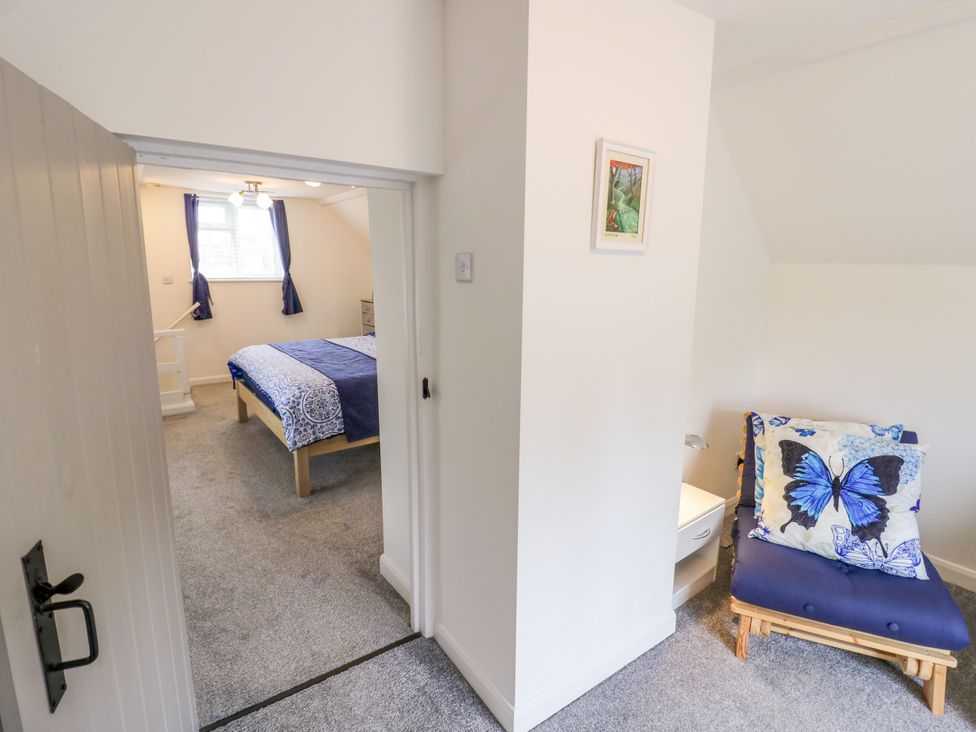 A bedroom with bed and chair at The Cottage in Ettington