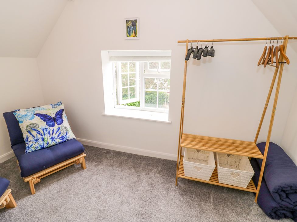 A room with two chairs and a hanger with baskets at The Cottage in Ettington