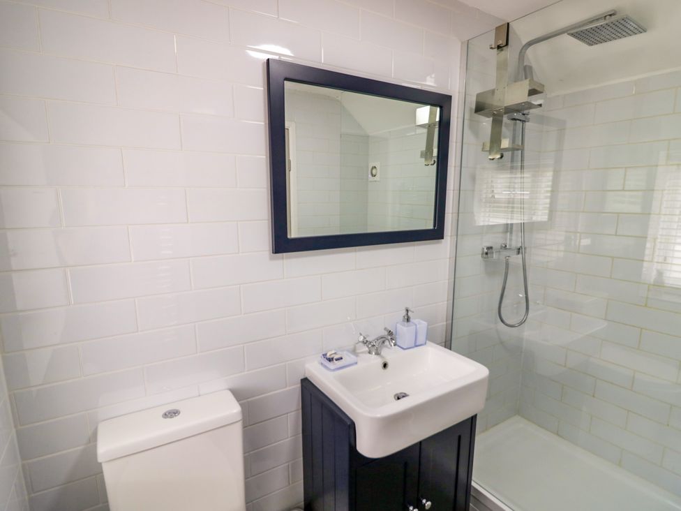 A bathroom with a sink, toilet, and shower at The Cottage in Ettington