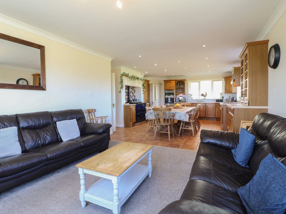 A living room with a sofa and dining area at Tixall Manor Farm in Tixall near Great Haywood