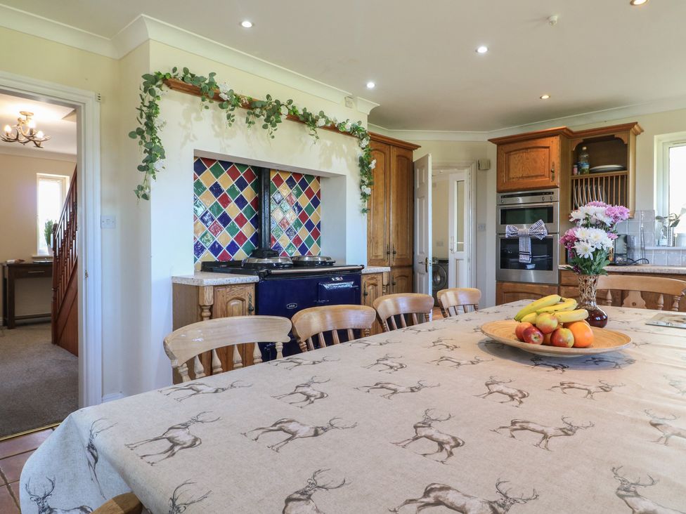 A kitchen with a table and chairs and cabinets at Tixall Manor Farm Tixall near Great Haywood