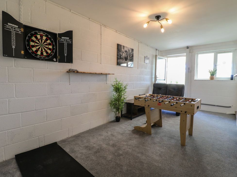 A game room with a dartboard and foosball table at Tixall Manor Farm in Tixall near Great Haywood