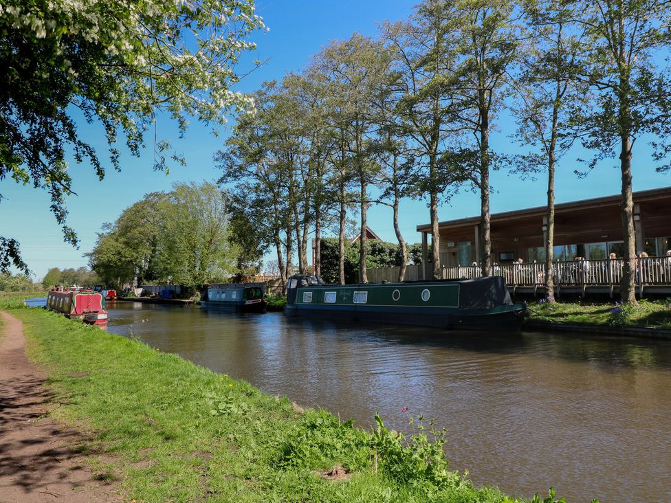 A canal with narrowboats and trees at Tixall Manor Farm Tixall near Great Haywood
