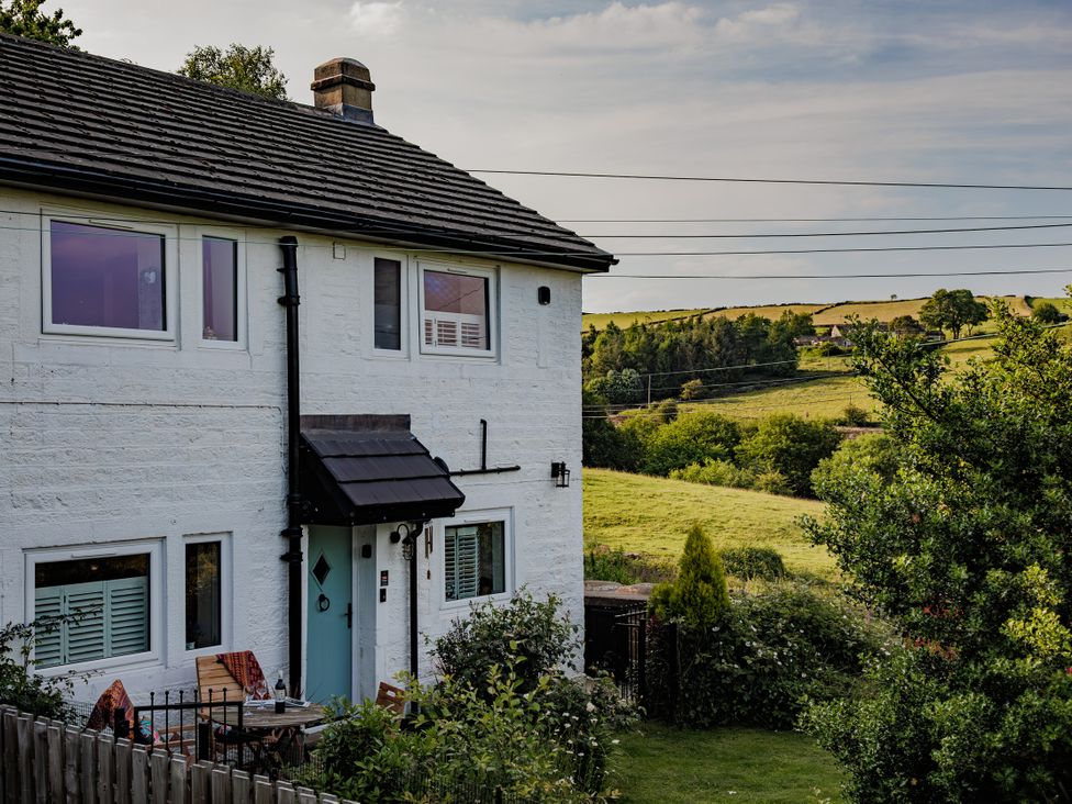 A house with garden and hills in the background at Wells Cottage in Holmfirth