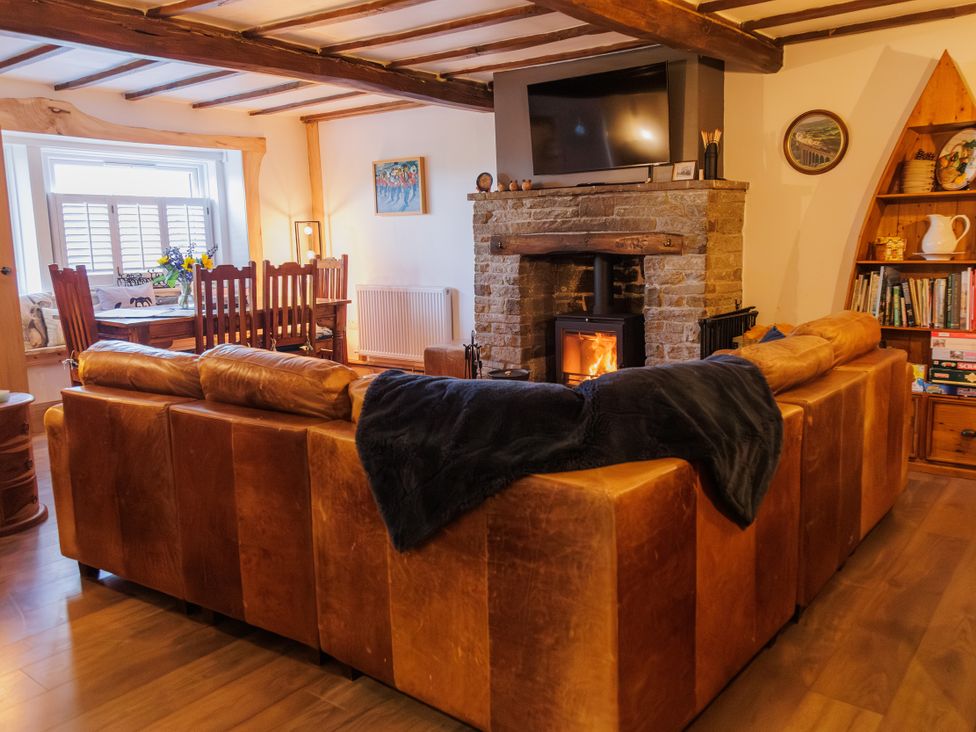 A living room with a sofa and a fireplace at Wells Cottage in Holmfirth