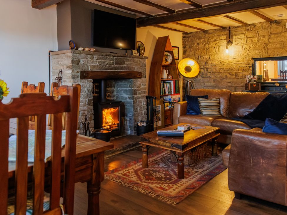 A living room with a fireplace and sofa at Wells Cottage in Holmfirth