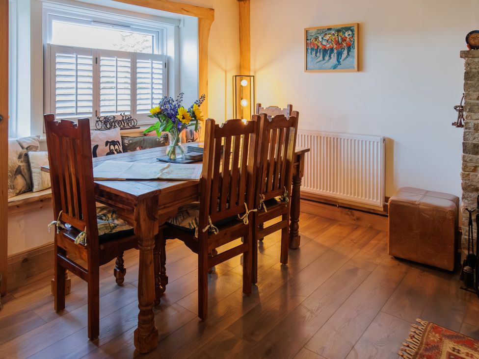 A dining room with a wooden table and chairs at Wells Cottage in Holmfirth