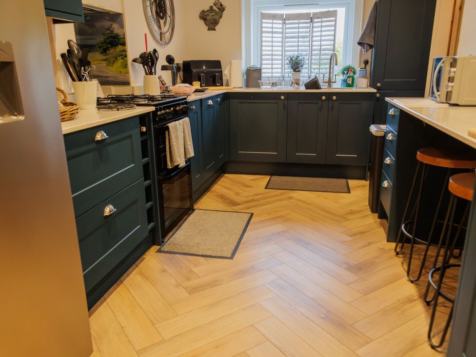 A kitchen with cabinets and appliances at Wells Cottage in Holmfirth