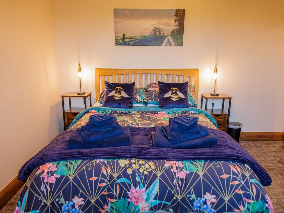 A bedroom with a bed and bedside tables at Wells Cottage in Holmfirth