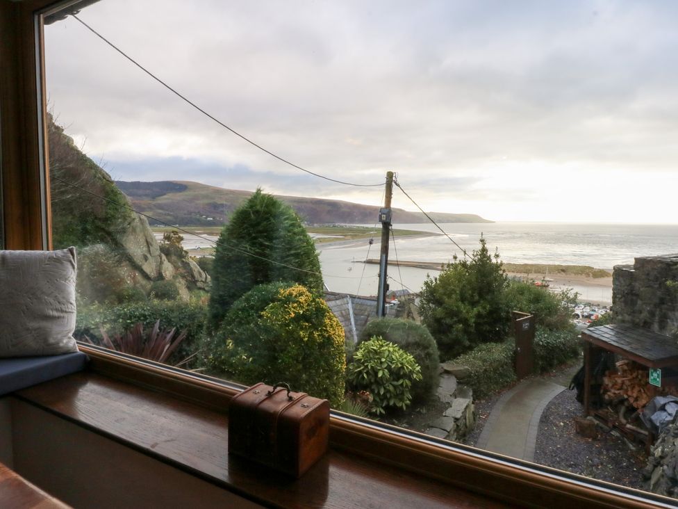 A view from a window showing the beach and sea at Ty'n-Y-Ffynnon Cottage in Barmouth