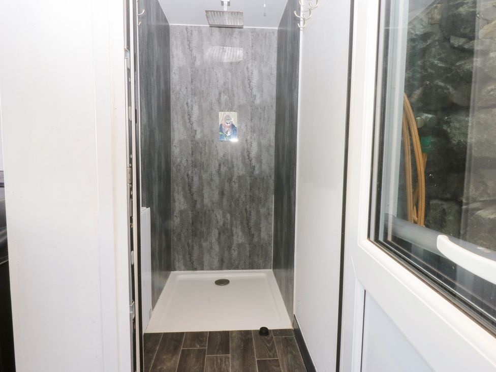 A bathroom with a shower and drain at Ty'n-Y-Ffynnon Cottage Barmouth
