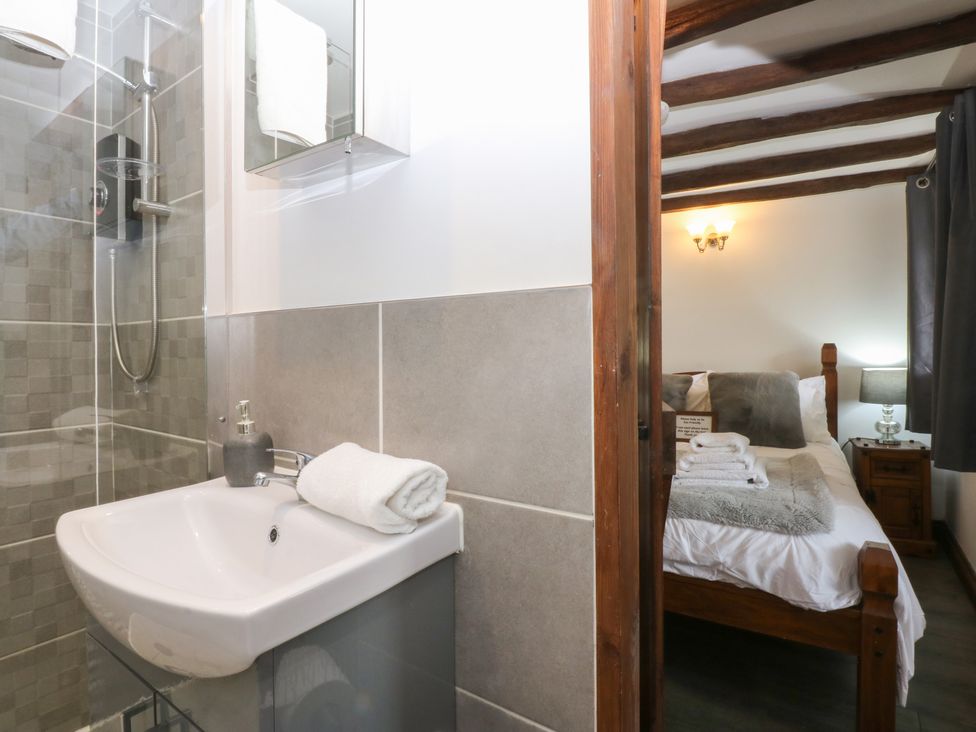 A bathroom with shower and wash basin at Ty'n-Y-Ffynnon Cottage in Barmouth