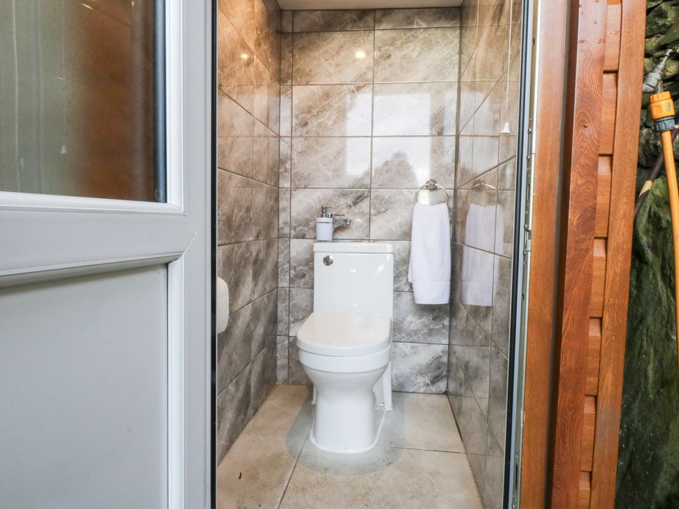 A bathroom with a toilet and sink at Ty'n-Y-Ffynnon Cottage Barmouth