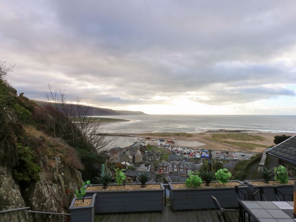 A view of the ocean and beach from a deck at Ty'n-Y-Ffynnon Cottage Barmouth