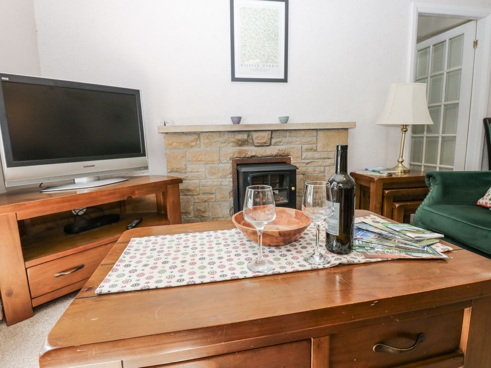A living room with a television and coffee table at Joyces Cottage, 2 Brown Hill Low Row near Reeth