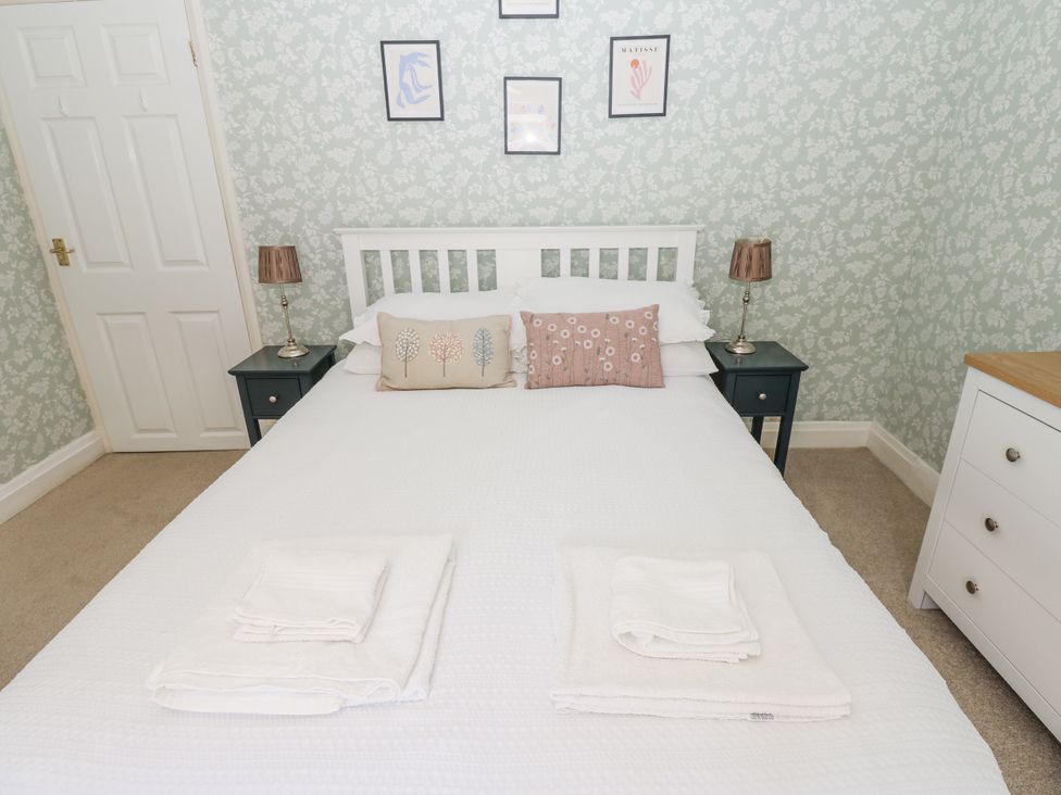 A bedroom with a bed and bedside tables at Joyces Cottage, 2 Brown Hill Low Row near Reeth