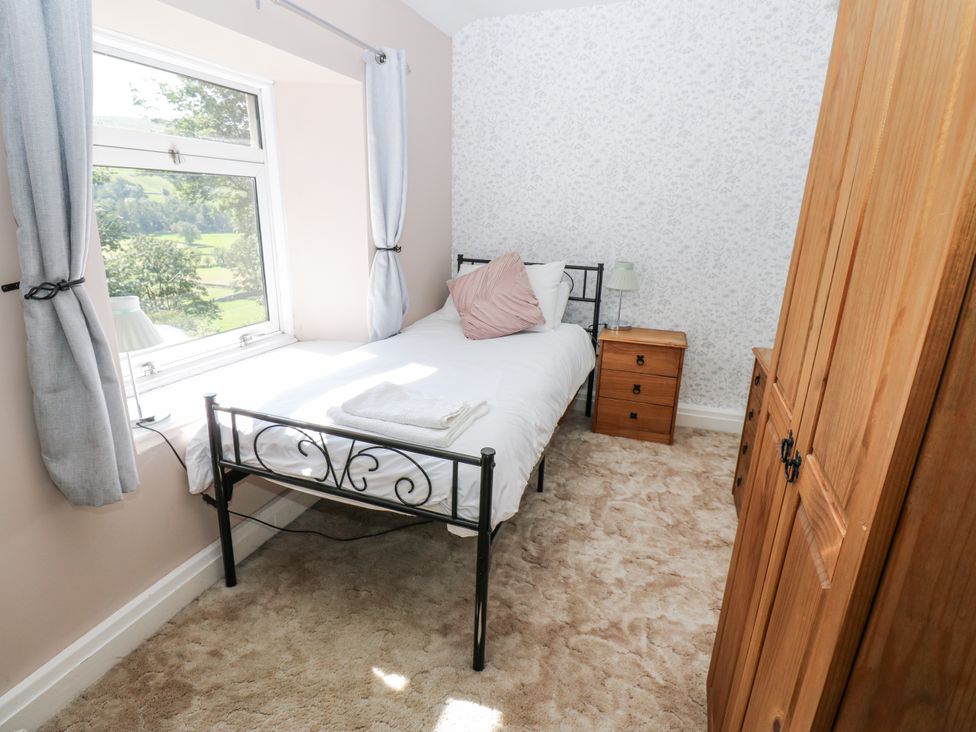 A bedroom with a single bed and a wardrobe at Joyces Cottage, 2 Brown Hill Low Row near Reeth