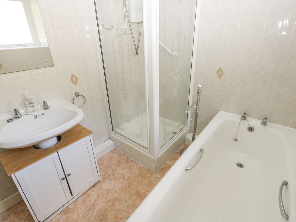 A bathroom with bathtub, shower, and sink at Joyces Cottage, 2 Brown Hill Low Row near Reeth