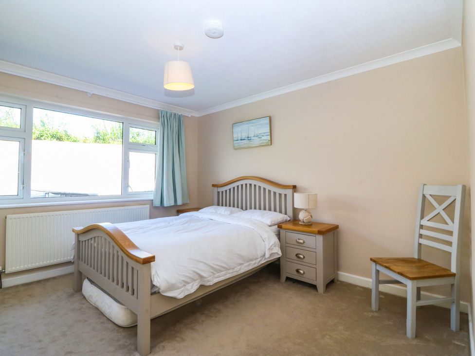 A bedroom with a bed and nightstand at 7 Maes Awel in Abersoch