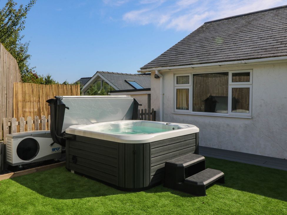 A hot tub with steps and an air conditioning unit at 7 Maes Awel in Abersoch
