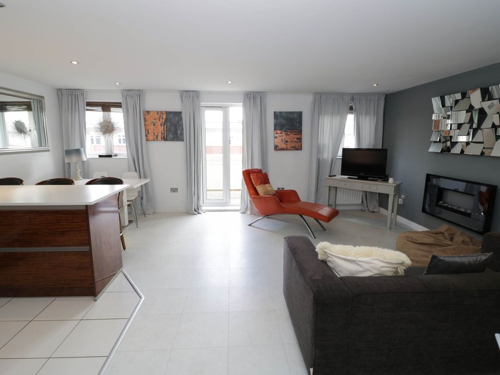 A living room with a sofa, television, and sliding door at 63 Vista Heights in Solihull