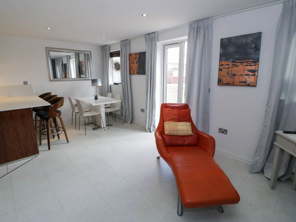 A living room with a chair and table at 63 Vista Heights in Solihull