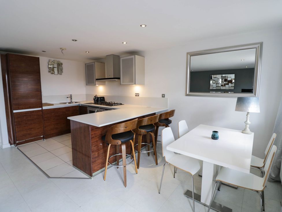 A kitchen with an island and dining area at 63 Vista Heights in Solihull