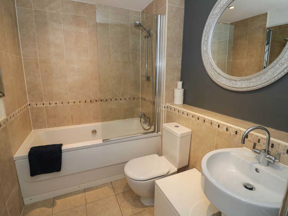 A bathroom with a bathtub, shower, toilet, and sink at 63 Vista Heights in Solihull