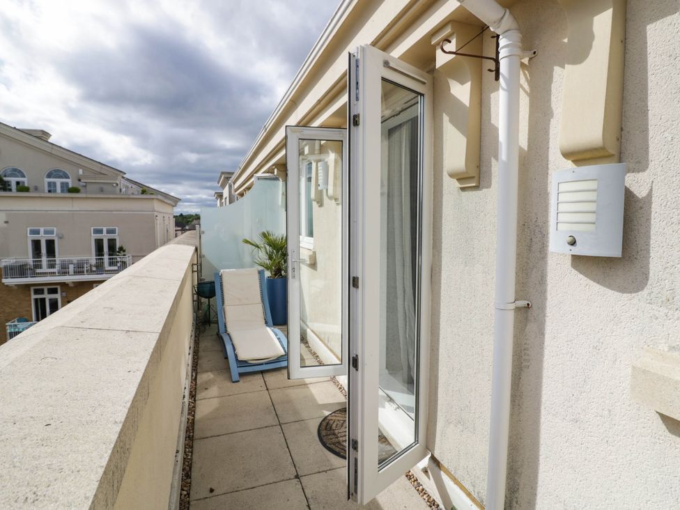 A balcony with a chair and plant at 63 Vista Heights Solihull