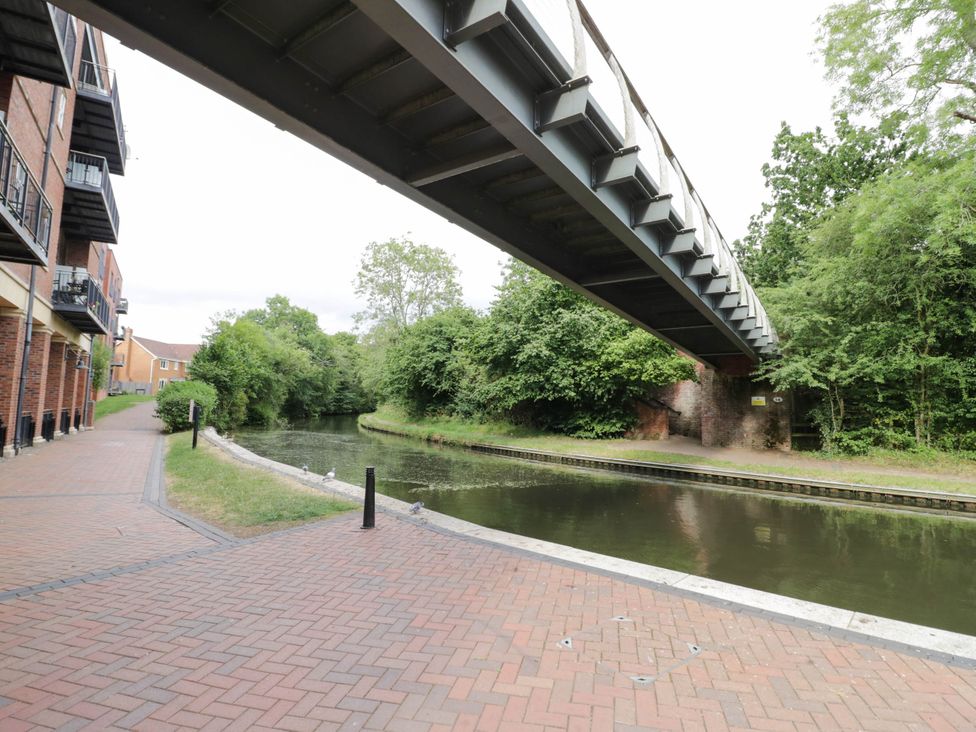 A view of a canal with a bridge and residential buildings at 63 Vista Heights in Solihull