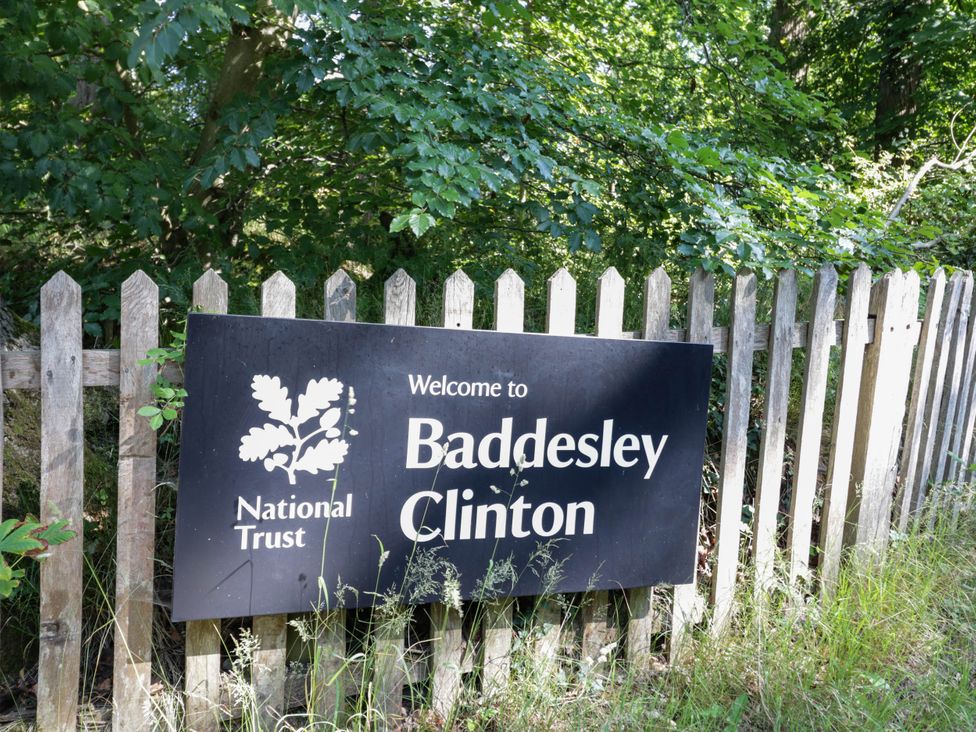 Welcome sign for Baddesley Clinton near a wooden fence and trees at 63 Vista Heights Solihull
