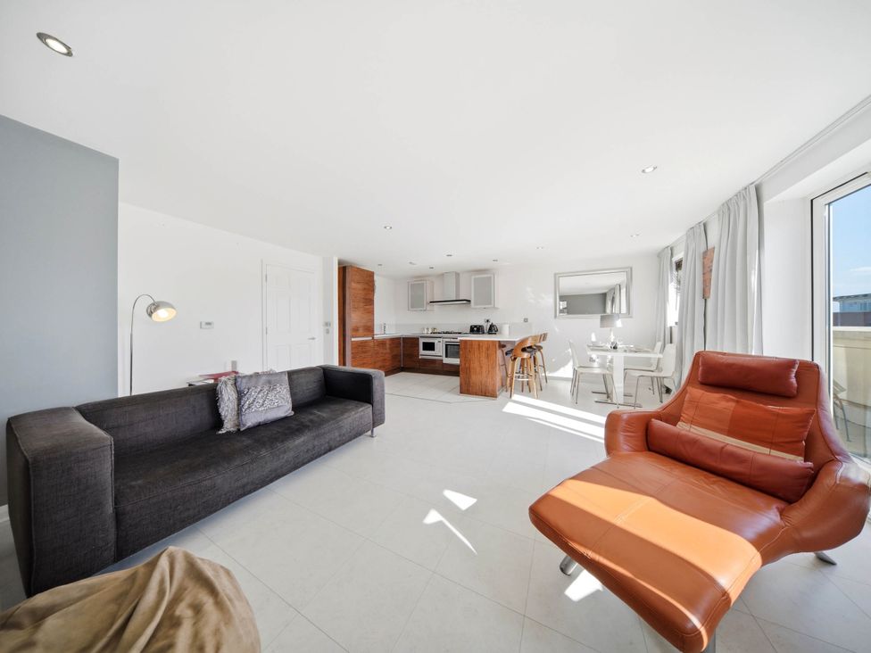 A living room with a sofa and kitchen area at 63 Vista Heights Solihull