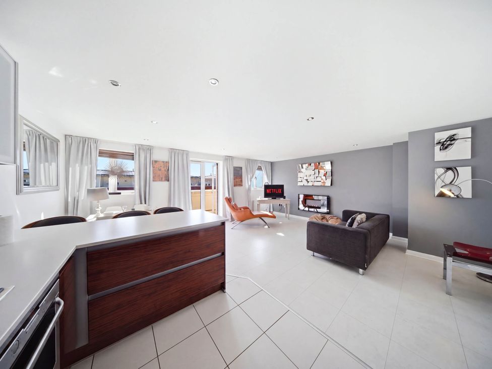 A living room with a sofa and dining area at 63 Vista Heights in Solihull