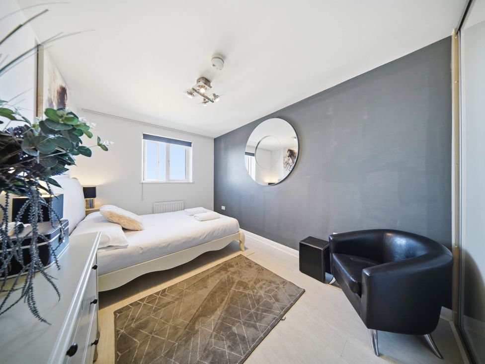 A bedroom with a bed and a mirror at 63 Vista Heights Solihull
