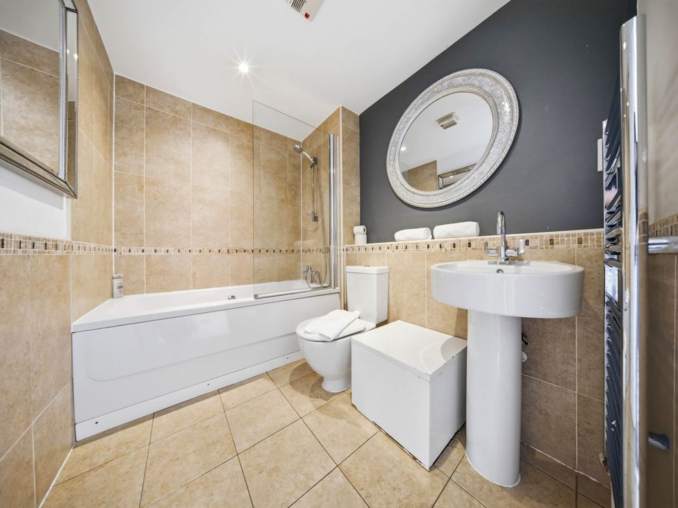 A bathroom with a bathtub, toilet, and sink at 63 Vista Heights in Solihull