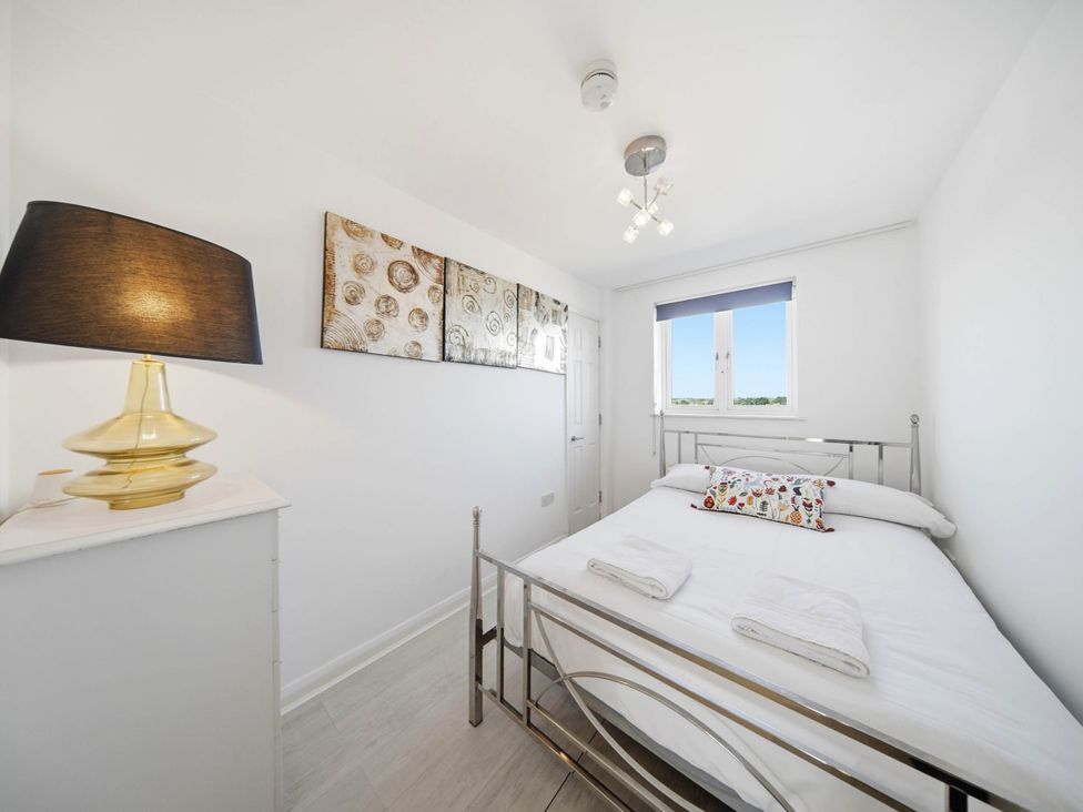 A bedroom with a bed and a bedside lamp at 63 Vista Heights in Solihull