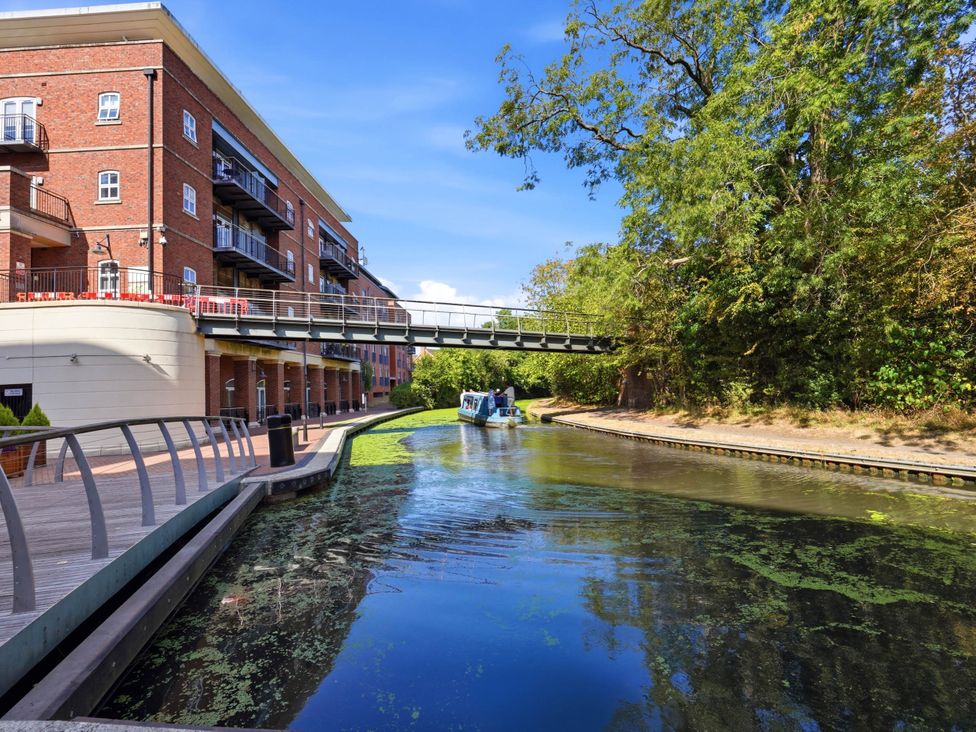 An outdoor area with a building, bridge, water, and trees at 63 Vista Heights in Solihull