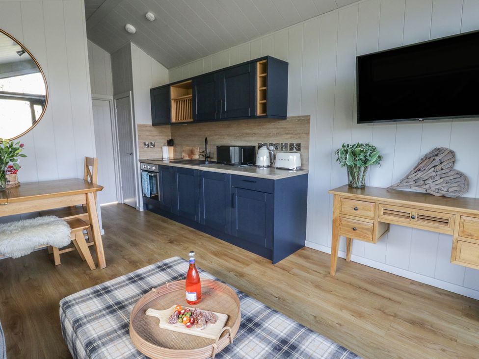 A kitchen with a table and stools at Fawn’s Rest Nantmel near Rhayader