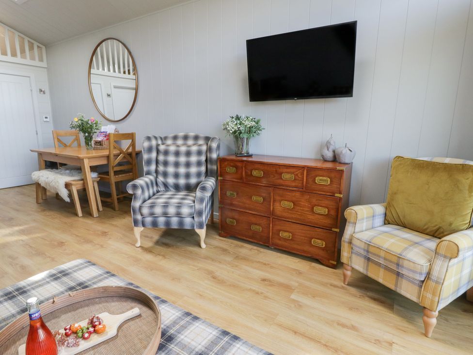 A living room with a dining table and chairs at Doe Lodge in Nantmel near Rhayader