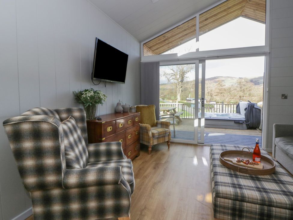 A living room with a sofa and television at Doe Lodge in Nantmel near Rhayader