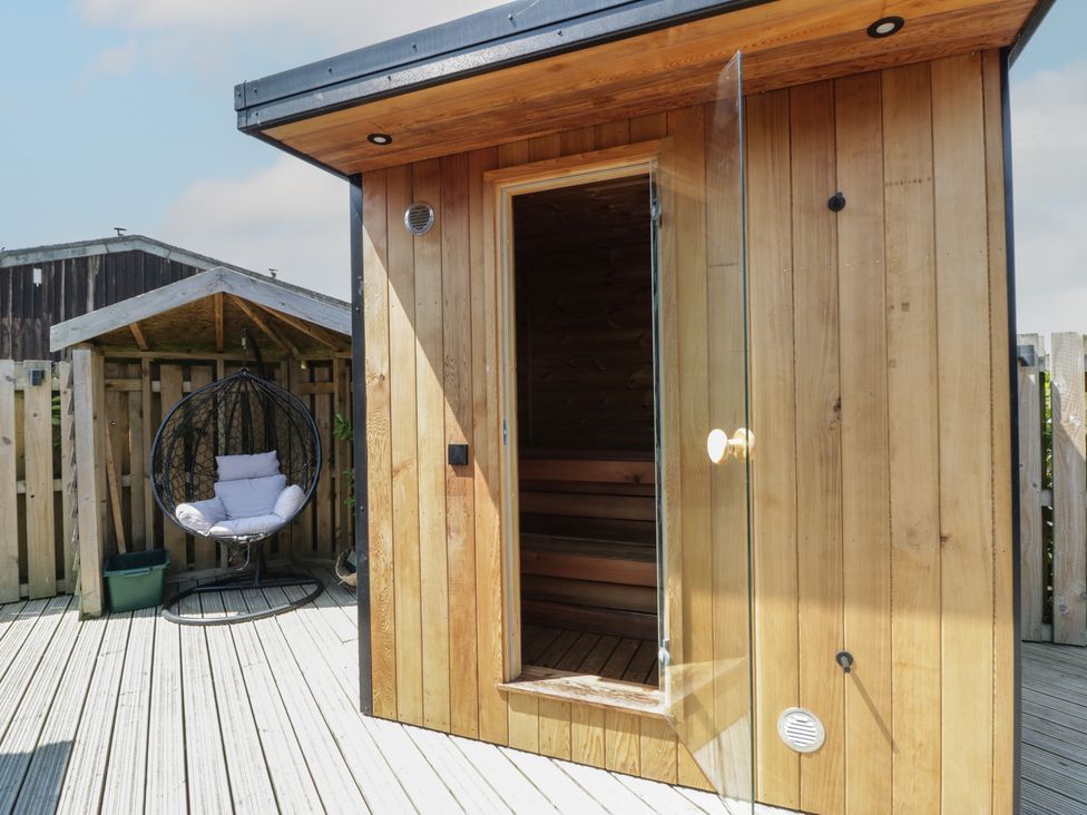 An outdoor area with a sauna and a hanging chair at Tin Shed in Nantmel near Rhayader