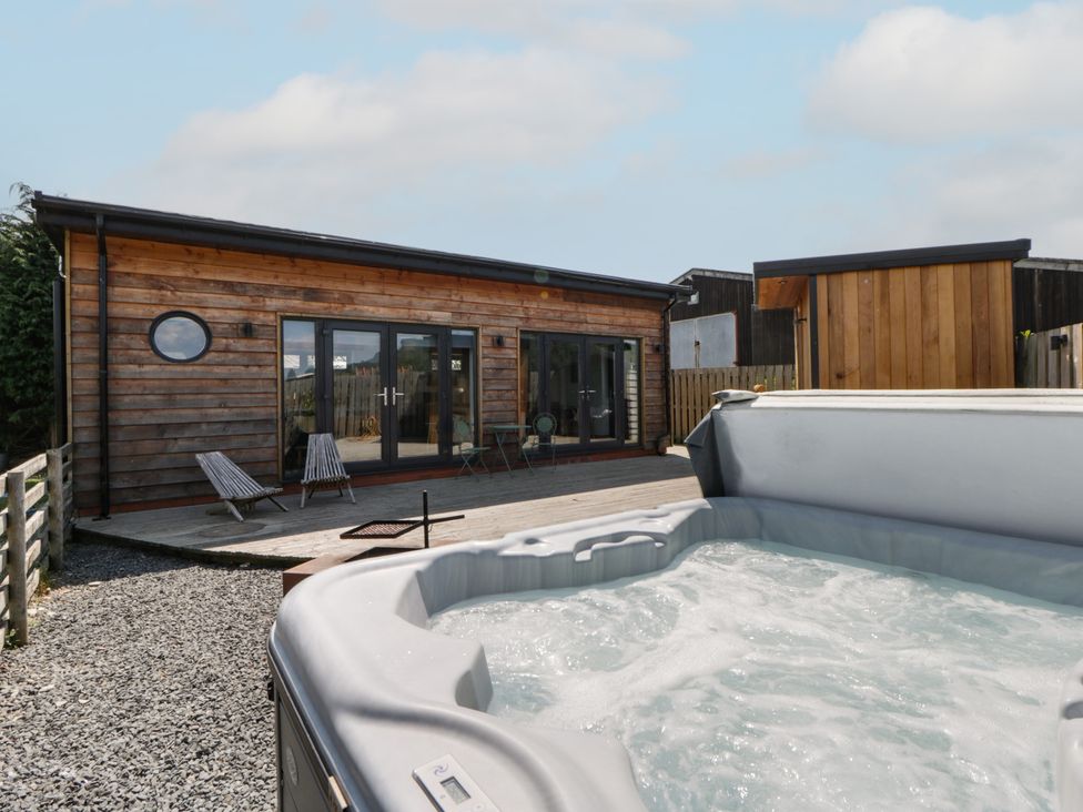 An outdoor area with a hot tub and wooden building at Tin Shed in Nantmel near Rhayader