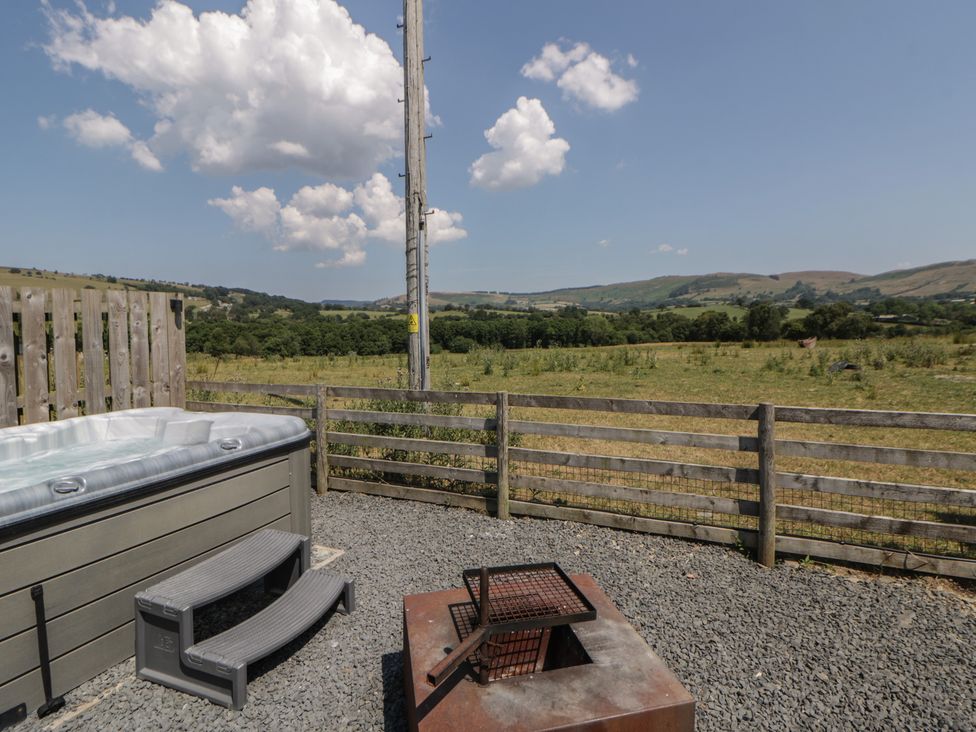 An outdoor area with a hot tub and fire pit at Tin Shed in Nantmel near Rhayader
