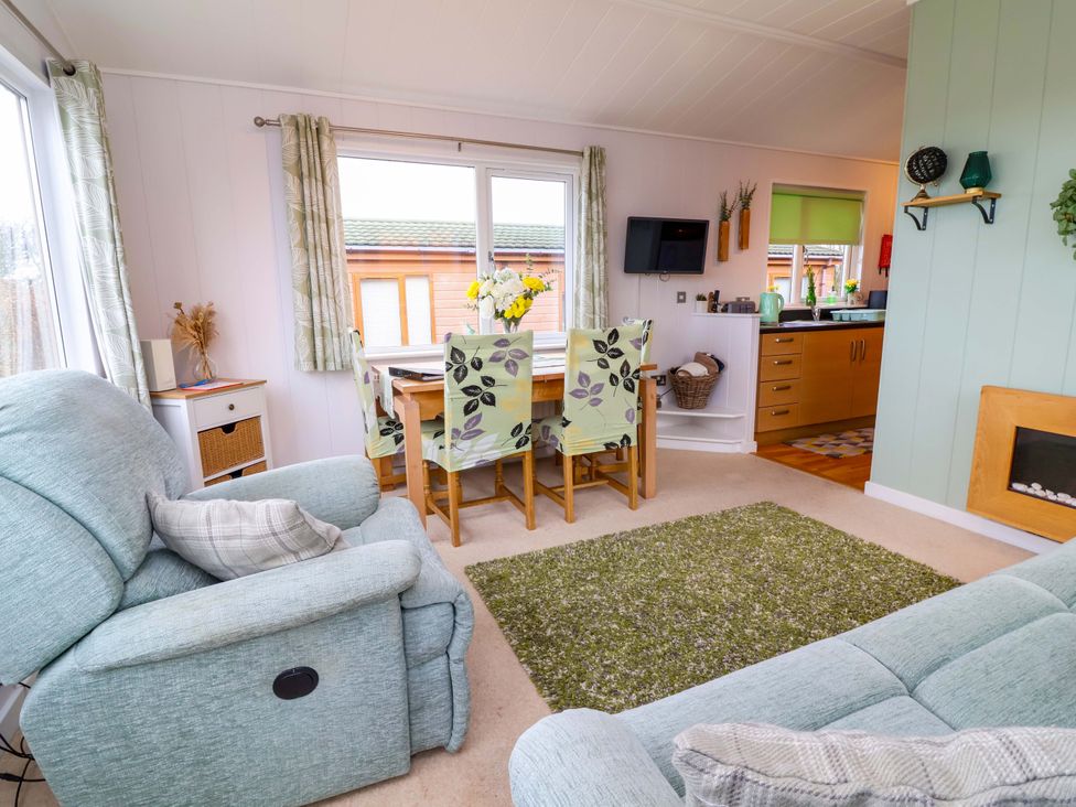 A living room with a dining area and kitchen at Daffodil Lodge Mullacott near Ilfracombe