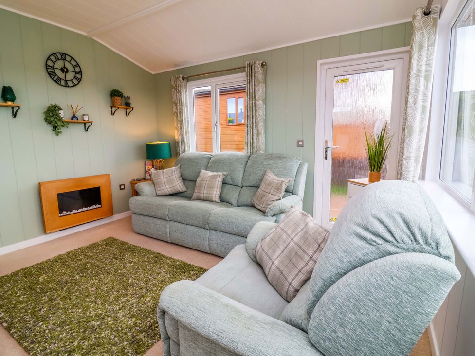 A living room with a sofa and armchair at Daffodil Lodge Mullacott near Ilfracombe