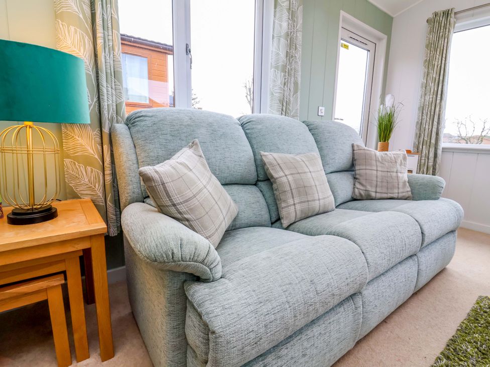 A living room with a sofa and side table at Daffodil Lodge Mullacott near Ilfracombe