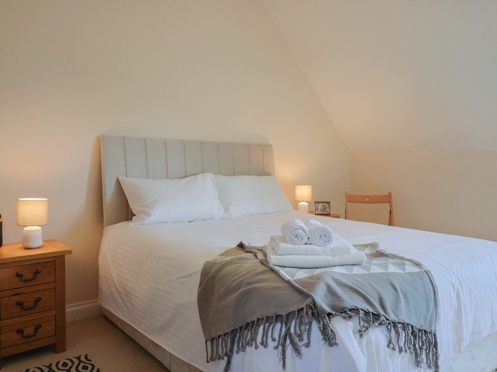 A bedroom with a bed and bedside lamp at 10 The Gardens in Rousdon near Lyme Regis