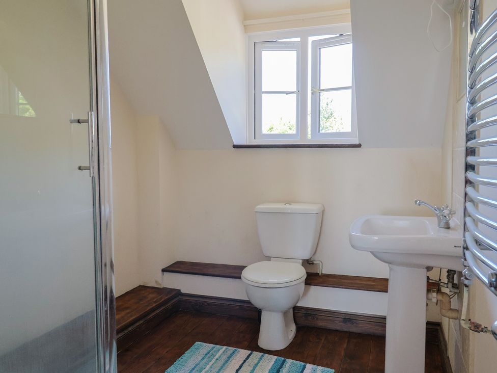 A bathroom with a shower, toilet, and sink at 10 The Gardens in Rousdon near Lyme Regis