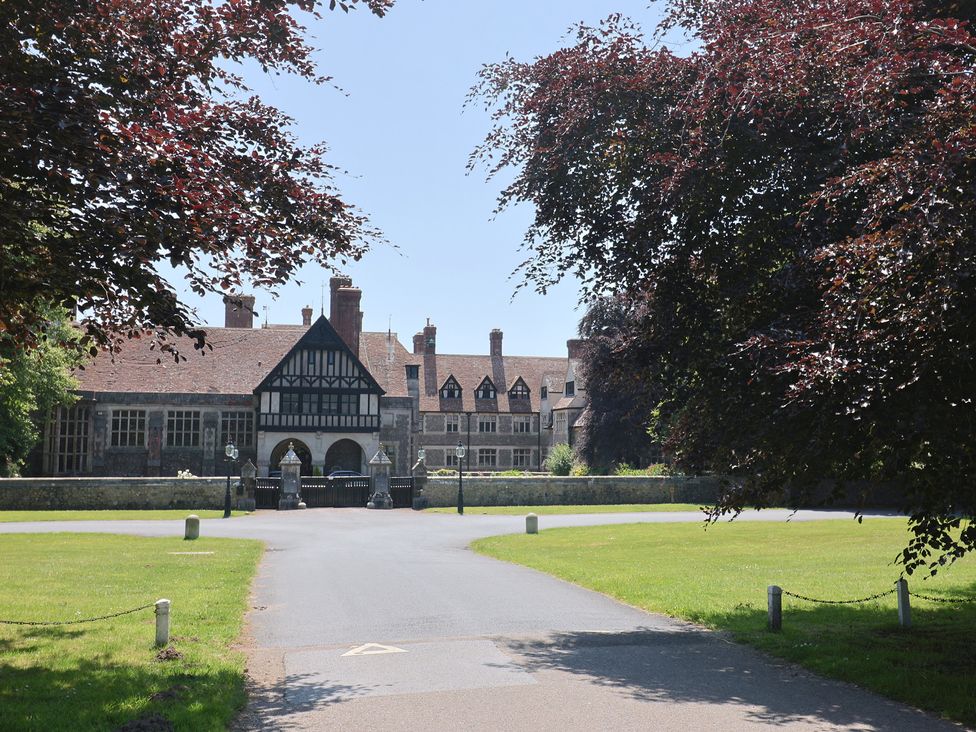 A large building with a driveway and trees at 10 The Gardens in Rousdon near Lyme Regis